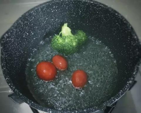锅内烧开水，西兰花沸水焯1分钟，圣女果烫一下去皮。