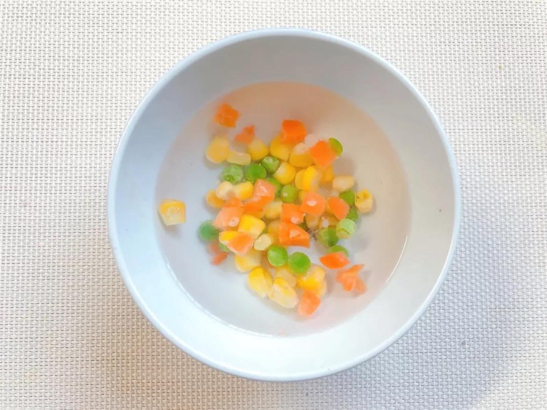 胡萝卜玉米青豆粒浸泡解冻，5分钟后捞出沥干水分。