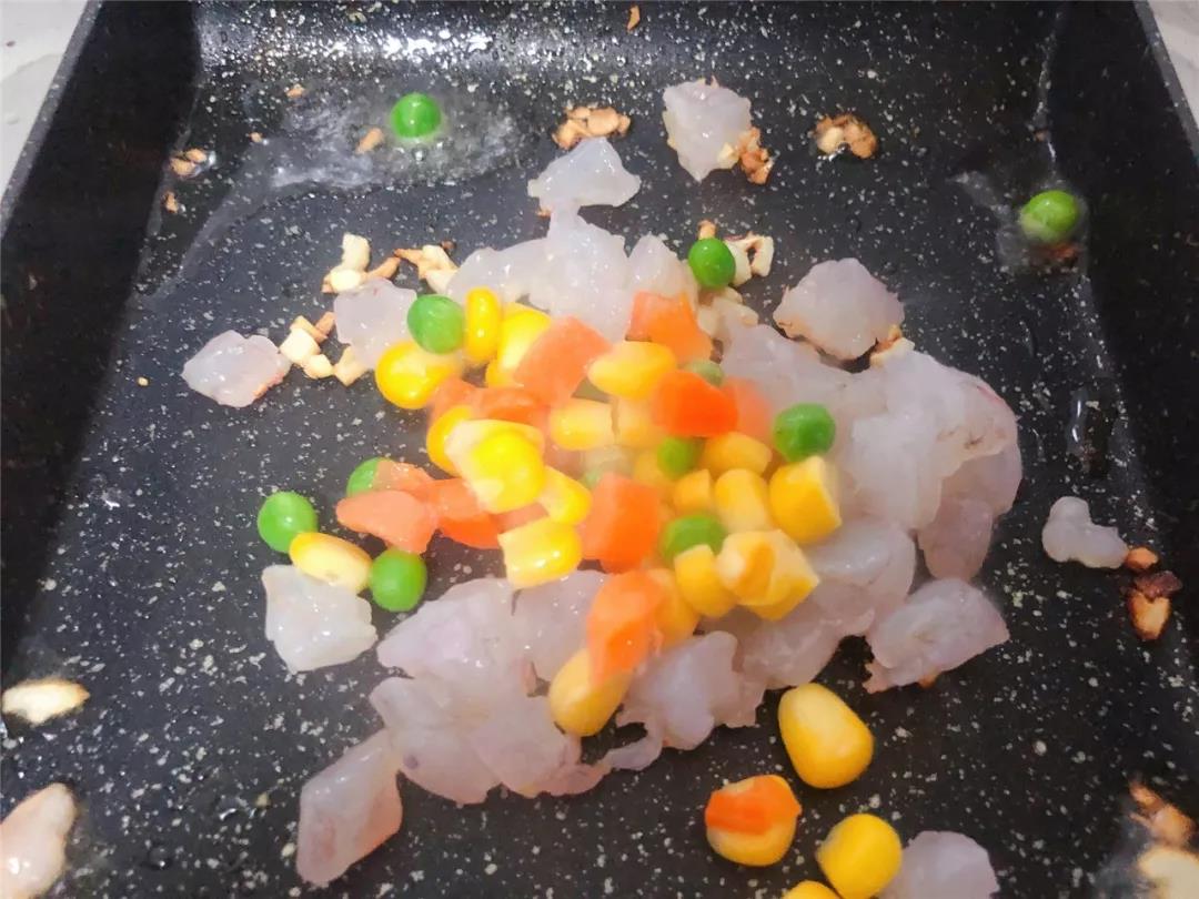 倒入虾仁和胡萝卜玉米青豆粒翻炒