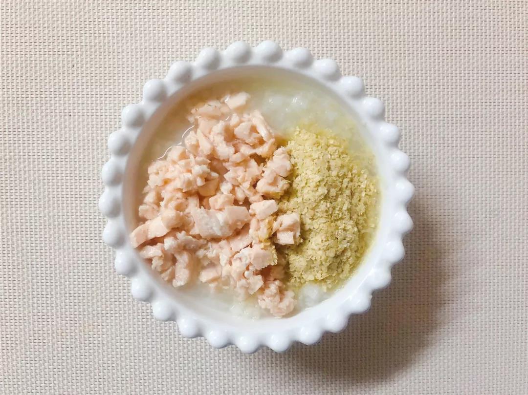 第6步：粥煮好取出，放入三文鱼碎和小麦胚芽，拌匀即可。