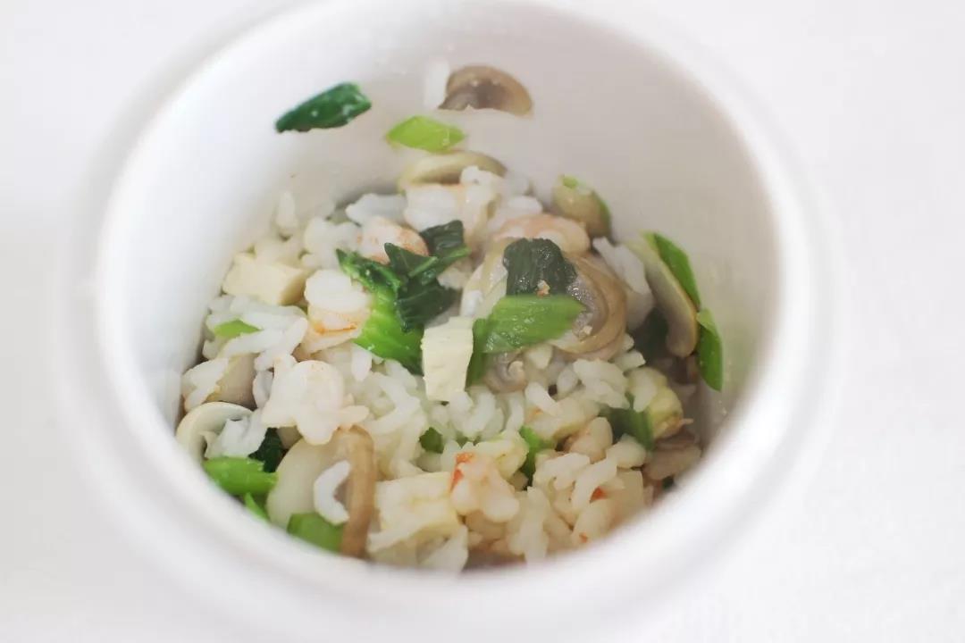 炒好的菜和白米饭加入油倒入炖盅翻拌均匀。