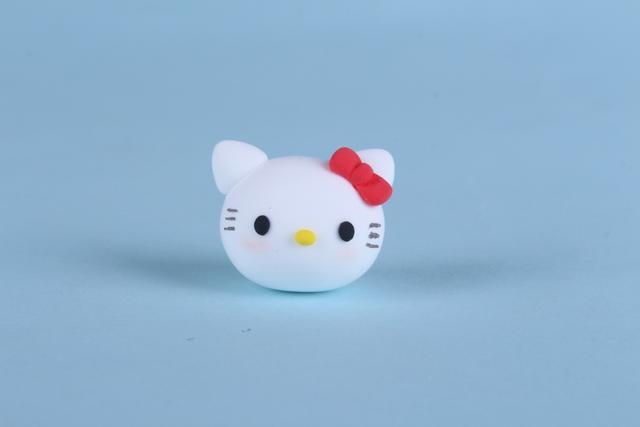 步骤3：用黑色粘土揉两个小圆球做眼睛粘好，然后黄色小圆球做鼻子，最后用笔画出胡须，再涂上一些腮红。