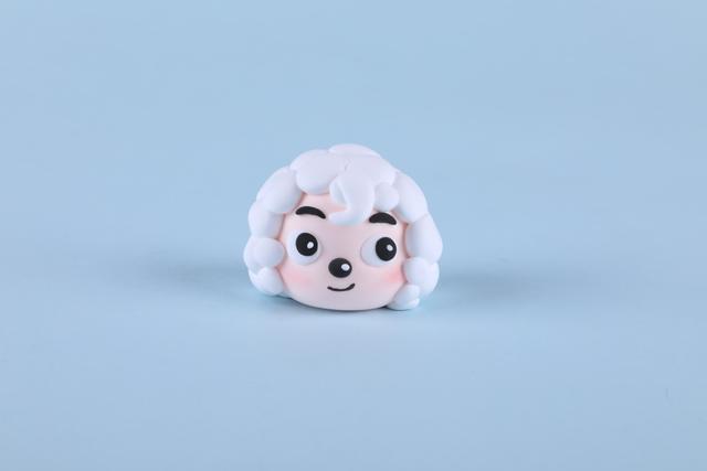 步骤5：把做好的小圆球粘到头顶做喜羊羊的毛发，前额粘上卷发。