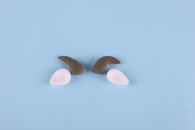 步骤6：肤色粘土做出小羊的两只耳朵，褐色粘土做出两只羊角。