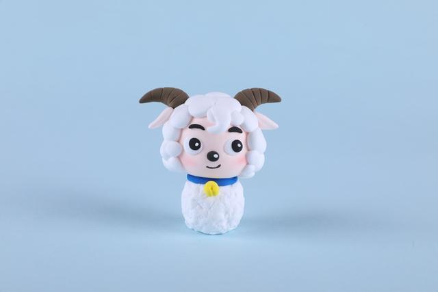 步骤9：把喜羊羊的头部和身体粘在一起，然后把铃铛挂在脖子里。