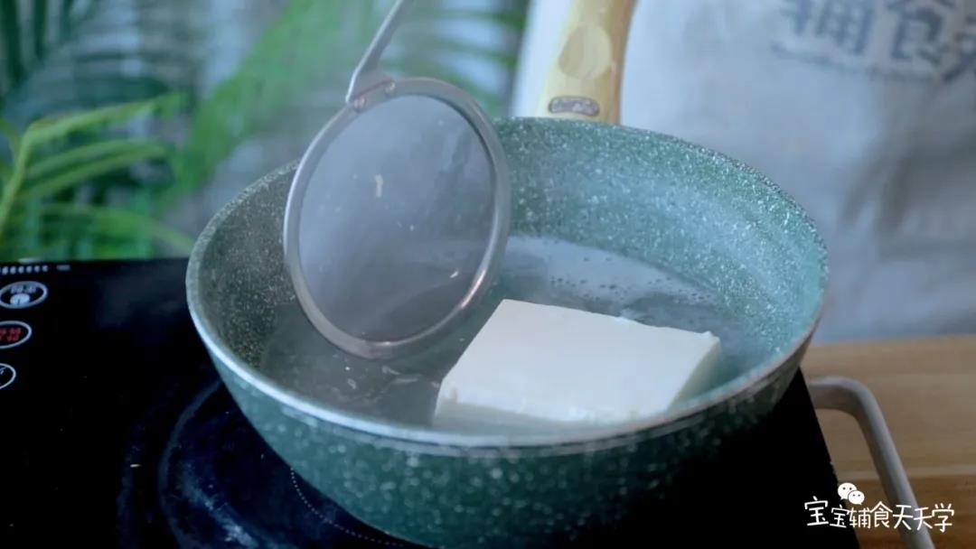 把豆腐淖水烫熟捞起，用勺子装进面碗中