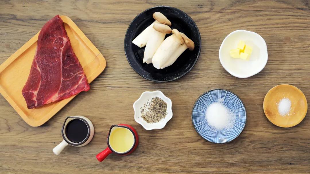 准备食材：牛排 / 一块(约200-250克)，杏鲍菇 / 4只，黄油 / 10克，生抽 / 10克，砂糖 / 5克，盐 / 1克，黑胡椒、食用油适量