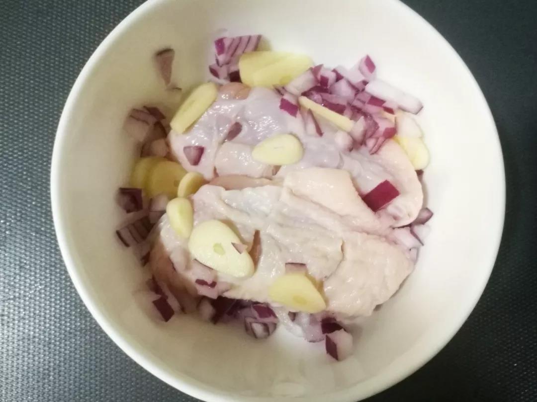 鸡翅洗净在表面划几刀，洋葱洗净切碎，蒜瓣切片，和鸡翅混合。