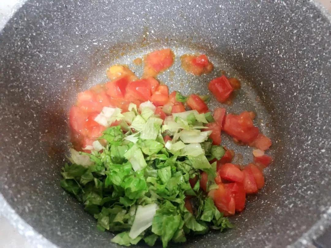 西红柿炒出红油后，放入生菜，继续翻炒。