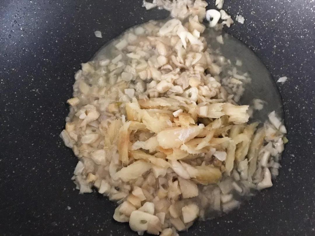 第4步：泡软的明太鱼干连同少量泡鱼干的水一起倒入锅中翻炒，焖至软烂。