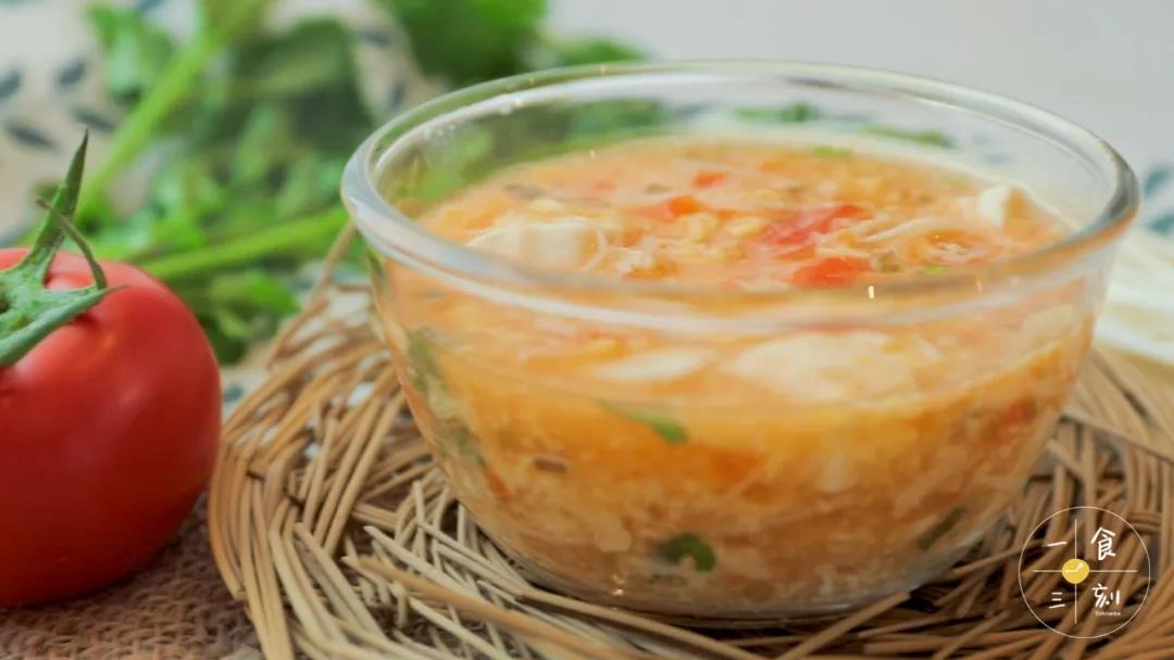 白嫩嫩的豆腐飘在红彤彤的番茄上，而翠绿的香菜点缀其中，一看就胃口大开。