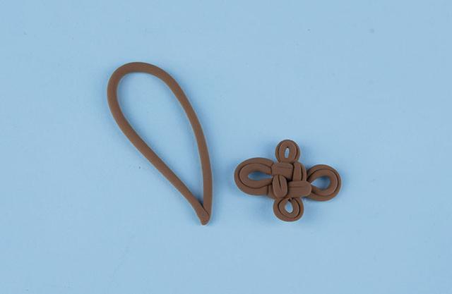 步骤3：然后用棕色粘土做出钱袋的绳子以及中国结