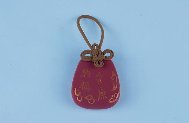 步骤4：把做好的挂绳粘在钱袋子上方，这样钱袋就做好啦！