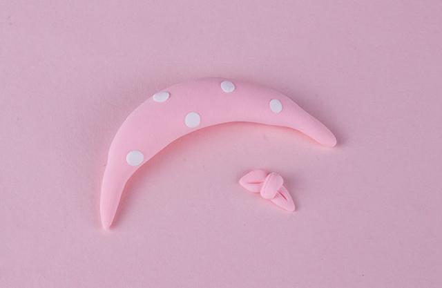 步骤8：最后我们用粉色的粘土做一个小围巾，上面点缀上白色圆点