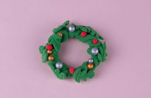 步骤6：把做好的树叶和小圆球粘在花环上作为装饰。