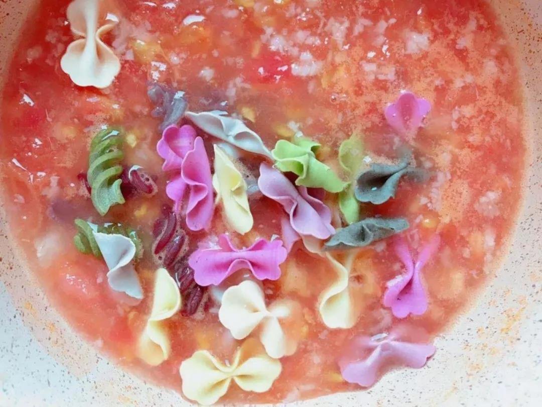 大火把水煮开了之后转小火，放入螺丝面和蝴蝶面，盖上盖子焖3分钟左右。