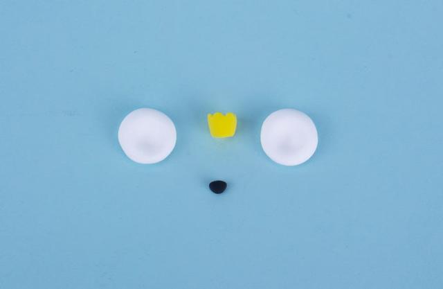 步骤2：然后用白色粘土做两个圆形作为耳朵，黑色粘土做鼻子，黄色粘土做一个皇冠。