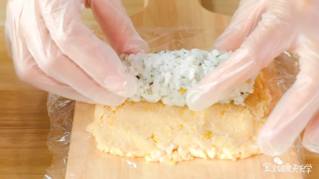 取适量的米饭戳成条状，叠放在备好的鸡肉泥上