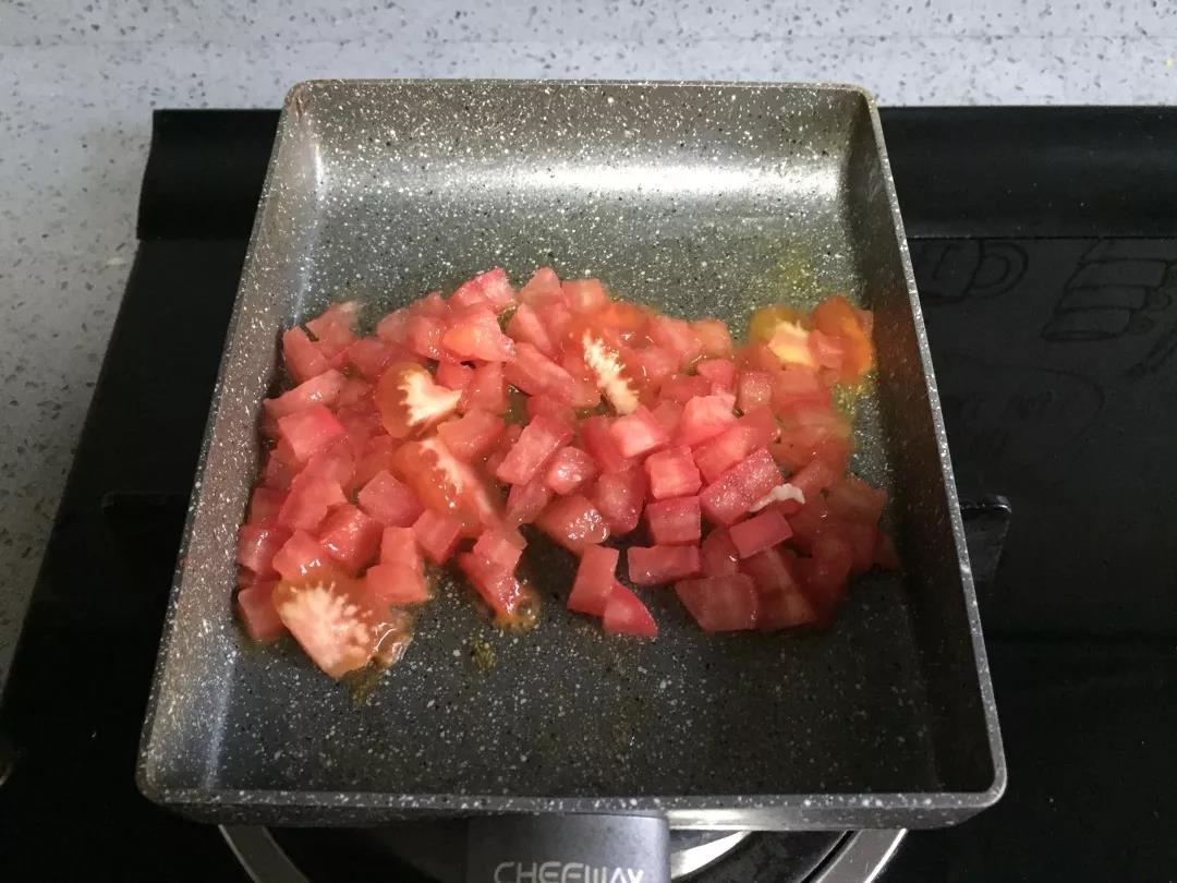 番茄丁放入油锅翻炒。