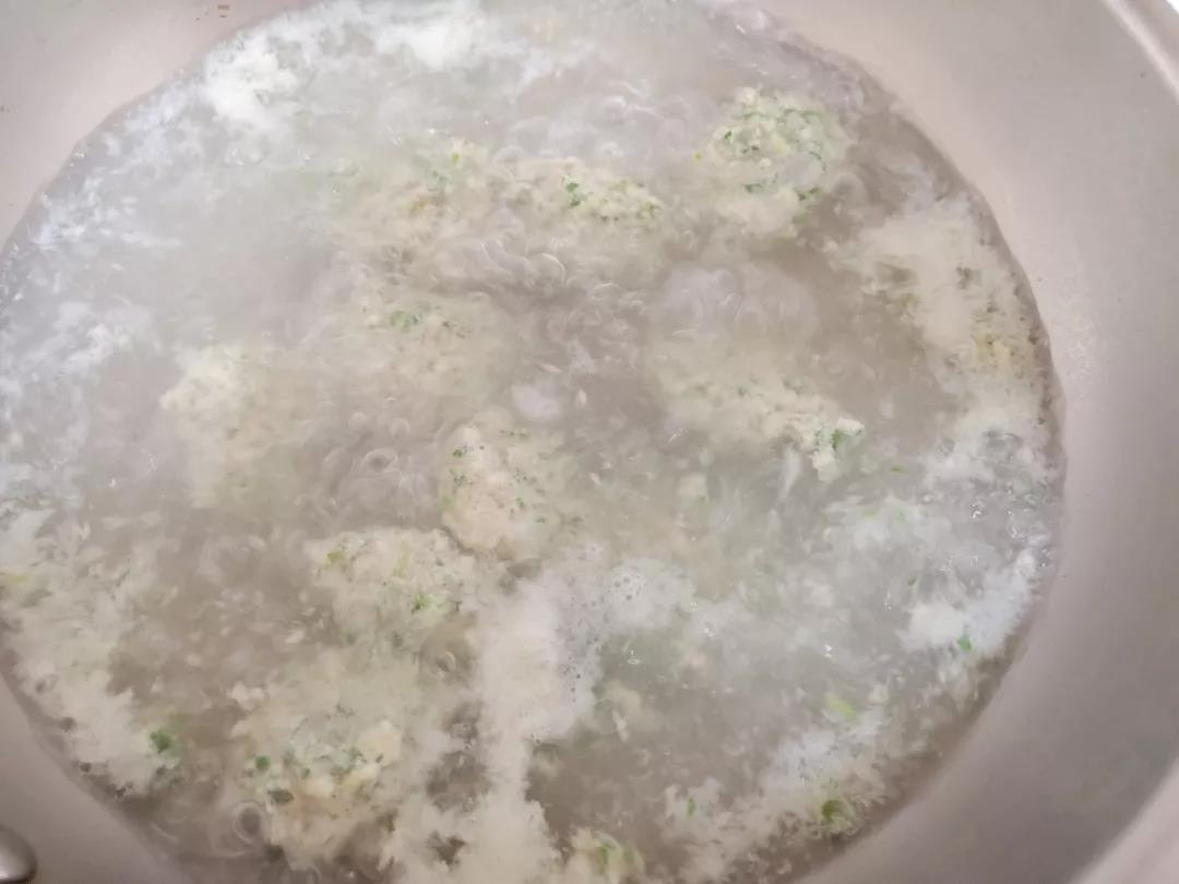 第6步：锅内加水烧开转小火，依次用勺子挖取少许肉糊，整成圆形，轻轻从锅边放入水中，全部放完转中火，肉丸浮起后再煮3-5分钟。