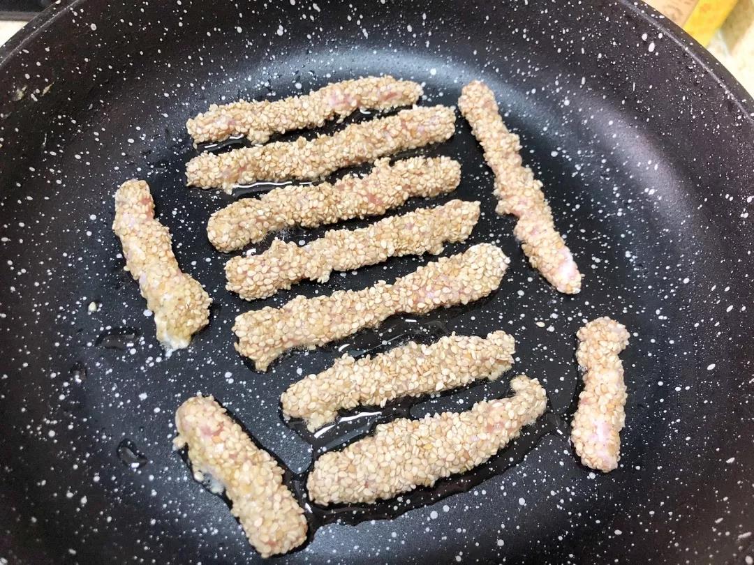 三文鱼条入油锅小火煎至定型。