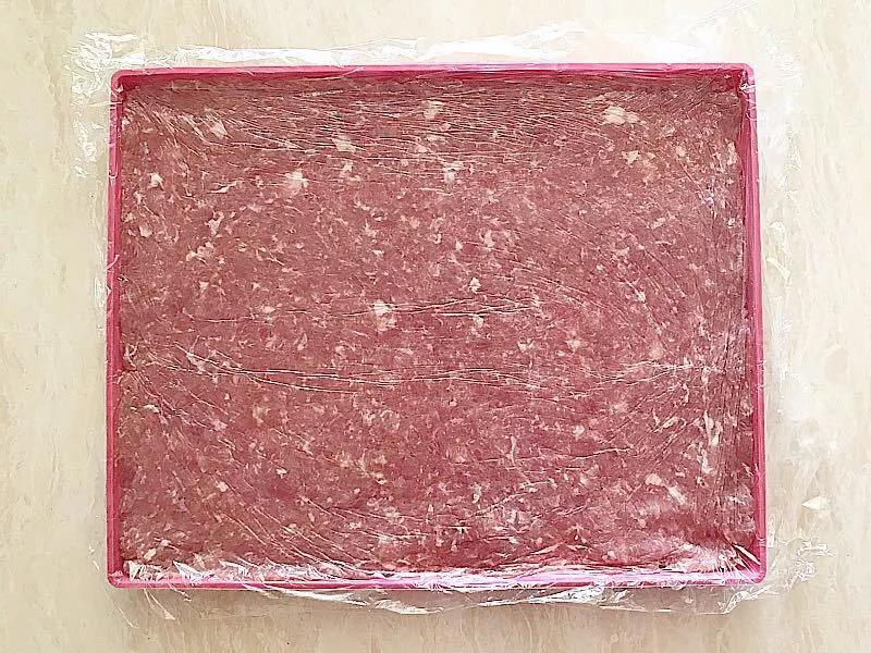 肉泥平铺在不粘烤盘上，加盖保鲜膜擀平擀薄，方子材料量大约是两盘。