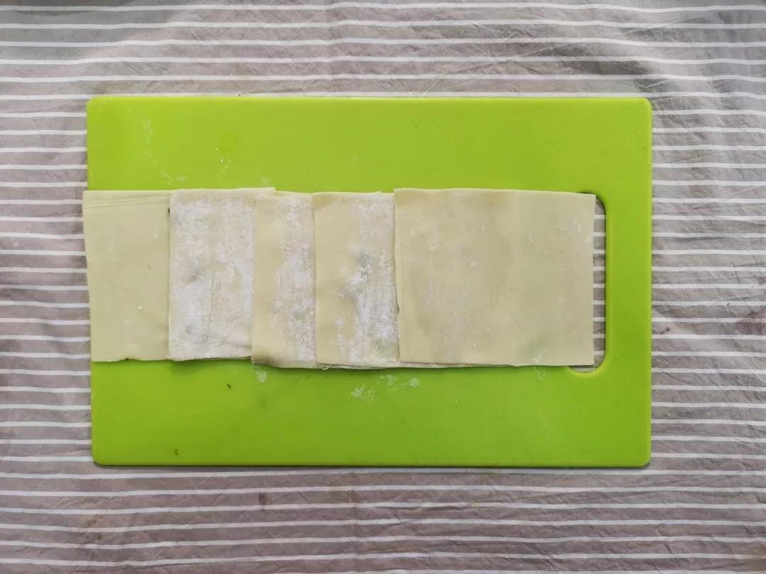 将馄饨皮依次叠加平铺成一排，交接处抹少许油。