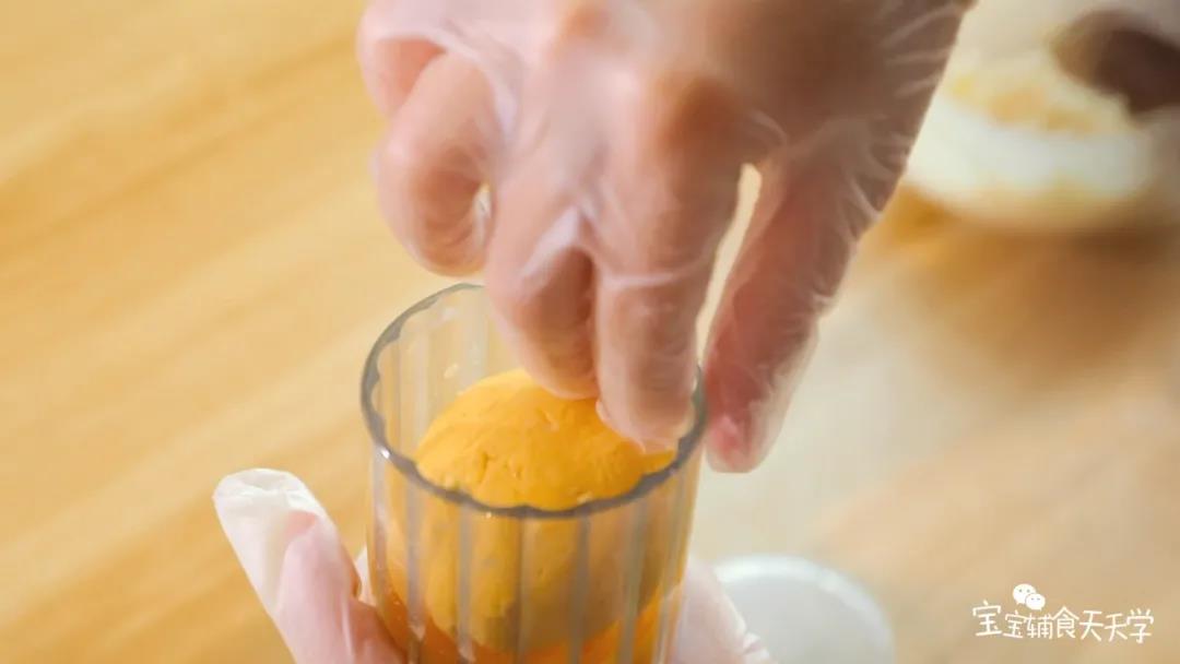 包好后封口处捏紧滚圆，把面团光滑的一面朝模具放下去