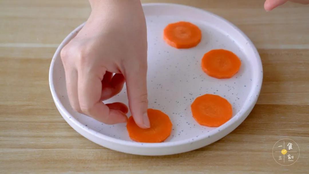 准备一个平底盘，放入胡萝卜片，再放上玉子豆腐