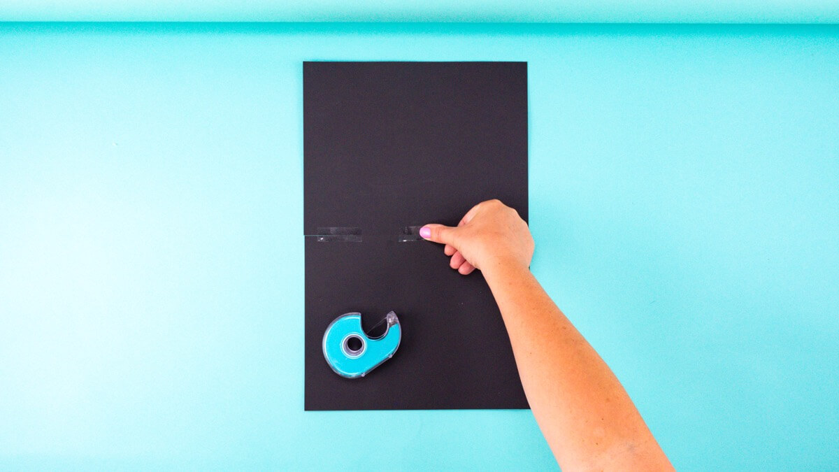 步骤2：将两张黑色卡纸的长边粘在一起。