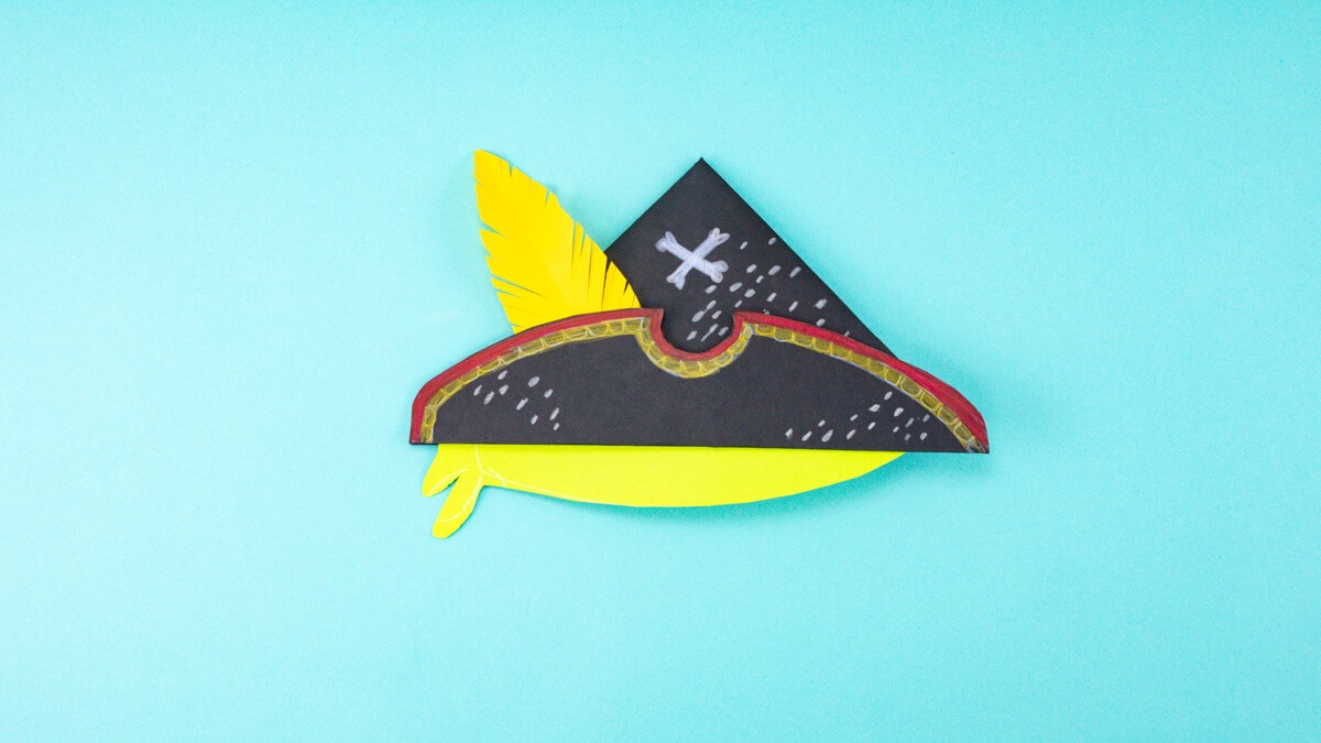 步骤9：画出你的头巾形状并将它粘在你的帽子上。您可以添加一根纱线，将海盗帽固定在您孩子的头上。