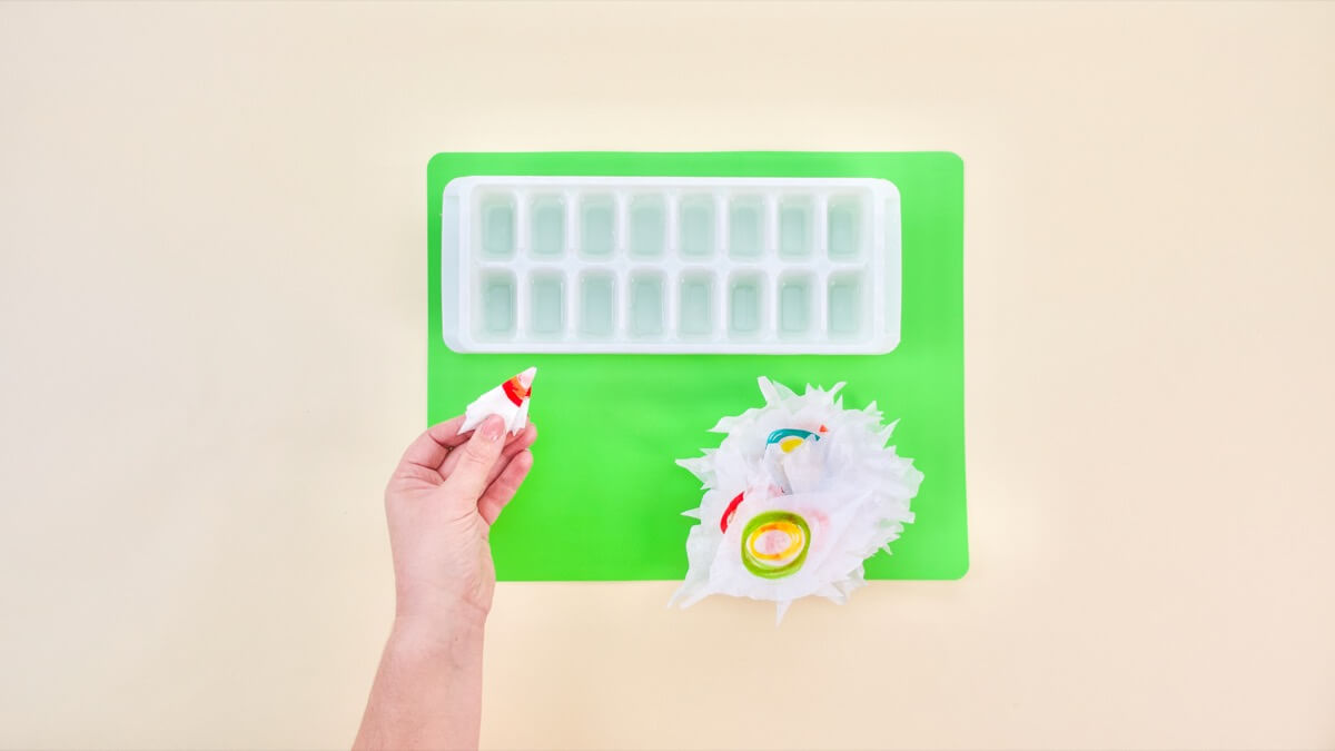 步骤4：现在是时候给你的叶子染色了！在这一步中，将冰块托盘装满约四分之一的水。将叶子折叠成锥形，末端有白色尖端。 