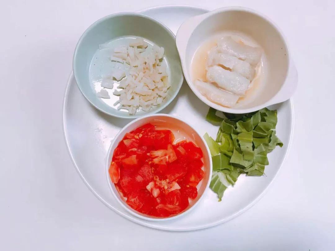番茄切小块，真鳕切段用柠檬汁腌渍。干贝提前浸泡后撕成丝，油菜叶切成条。