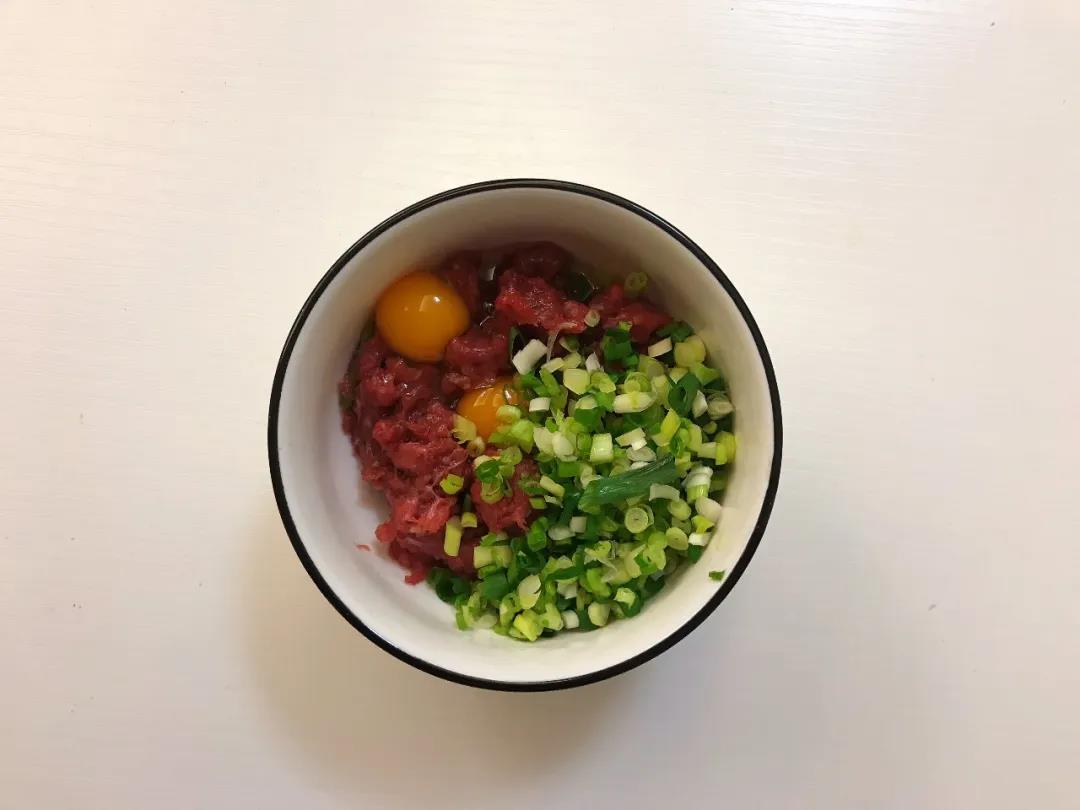 鹌鹑蛋洗净打散，和油、香葱碎一起放入牛肉泥中。