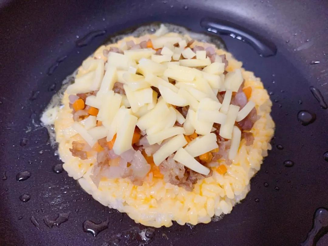 再撒上切碎的奶酪，盖盖小火焖至奶酪融化、蛋液完全凝固。