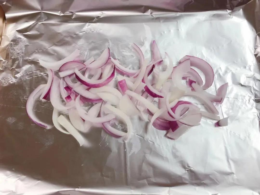 第6步：烤盘铺上锡纸，均匀放上2/3的洋葱。