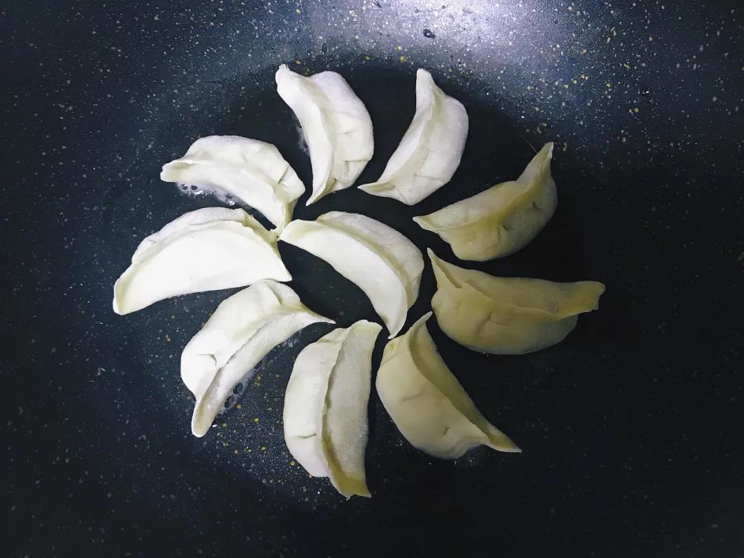 饺子放入平底锅中煎至底部金黄。