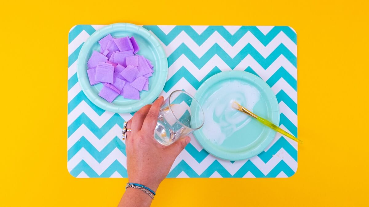 步骤3：在纸盘上混合白色工艺胶和少许水。这将使胶水更容易刷到纸巾方块上。  