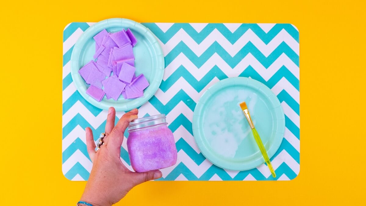 步骤4：分段工作。首先用胶水涂抹罐子的第一部分。使用相同的刷子轻轻拿起薄纸方块并将它们放下，将方块重叠并分层。为了加强颜色，在第一层干燥后添加第二层。 提示：您可以使用吹风机加快干燥过程。  