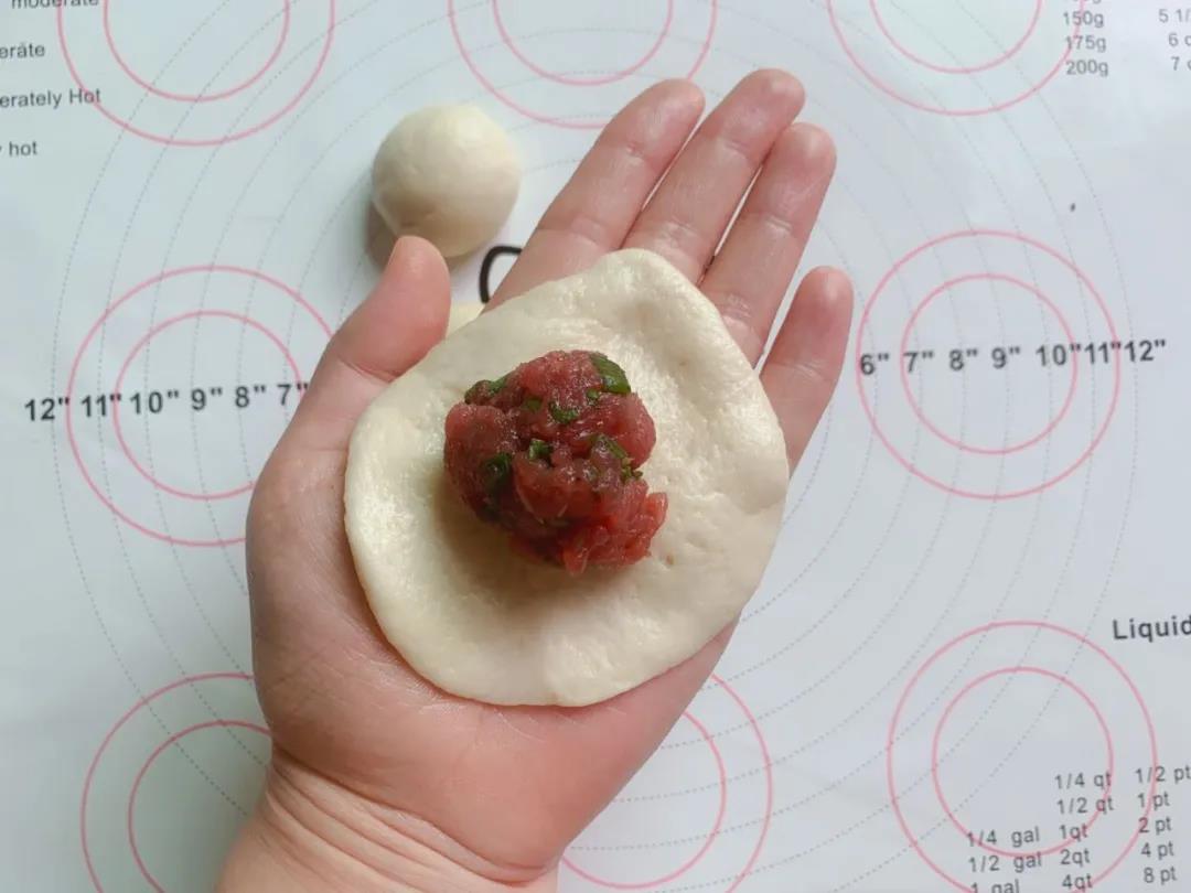 第9步：面团按压成圆片，包入适量馅料。