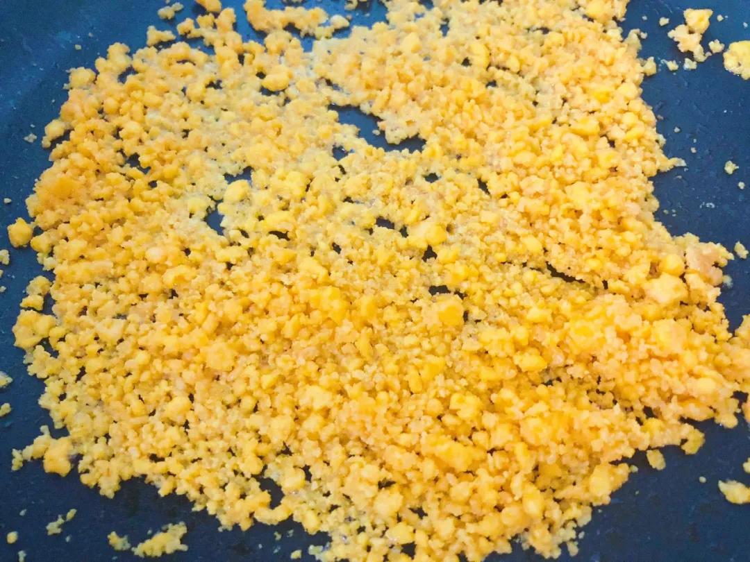 蛋黄碎倒入油锅，小火慢慢翻炒至冒泡。