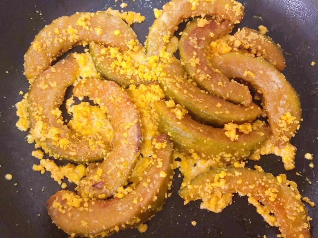 继续放入南瓜块，和蛋黄碎翻炒均匀。