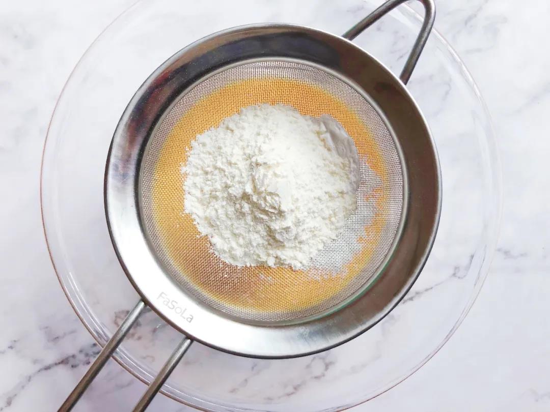 筛入低筋面粉和淀粉，划“Z”字型搅拌成细腻、无颗粒的蛋黄糊。