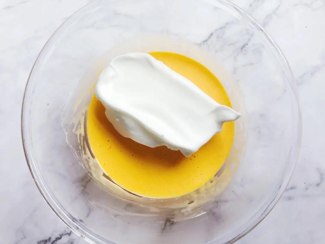 取1/3的蛋白霜和蛋黄糊混合，用炒菜的方式翻拌均匀。