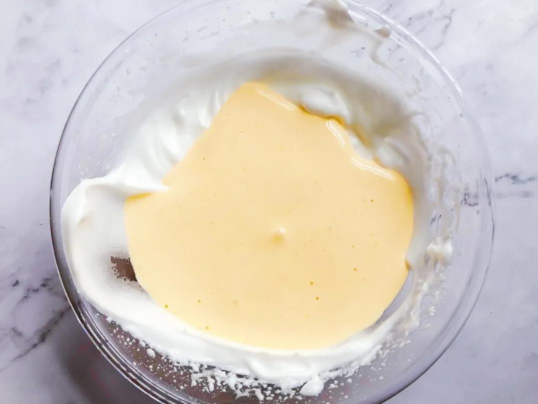 再将混合好的糊倒回到剩余的蛋白霜里，继续翻拌混合均匀。