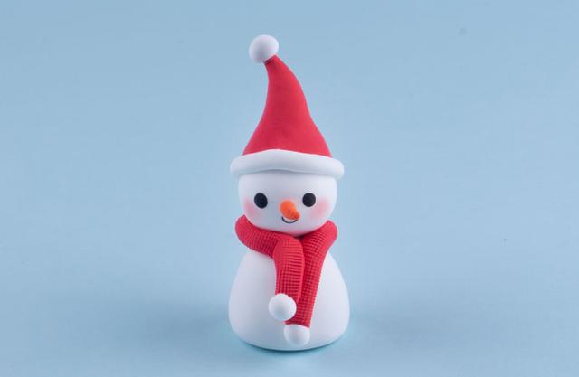 步骤7：把围巾给雪人戴好，然后白色圆球粘到围巾两端做装饰。