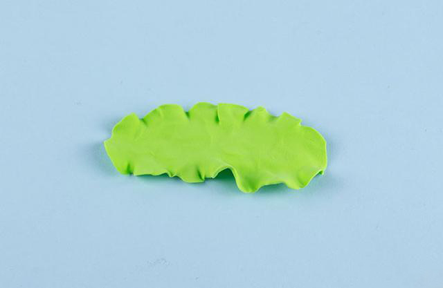 步骤3：用青草绿色的粘土压成薄片，然后边缘扯一下，做出生菜的样子。