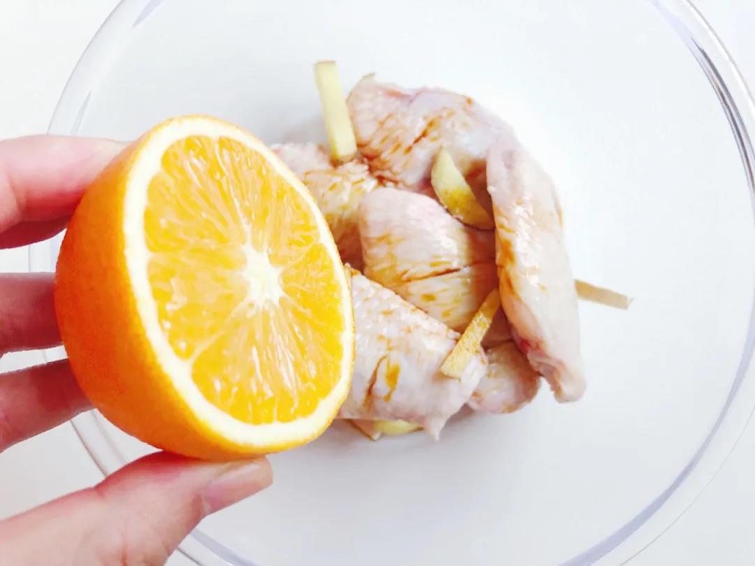 鸡翅中放入姜、酱油、芝麻油，再挤入半个橙子汁。