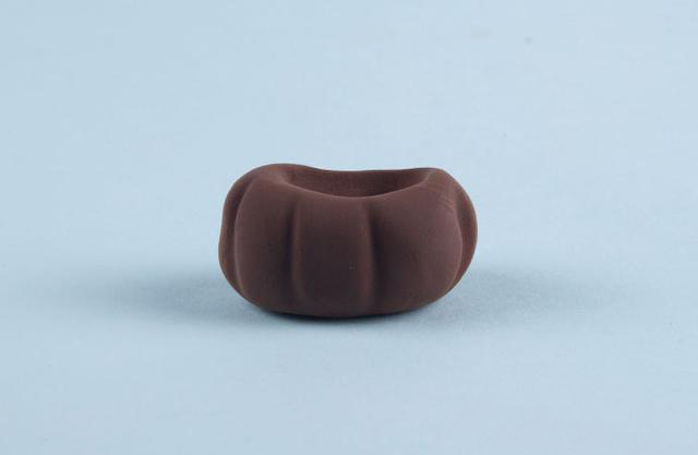 步骤9：下面开始做团子的身体部分，先用咖啡色粘土做出上图的形状，这是小裙子。