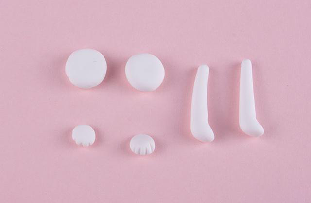 步骤5：接下来做九月的四肢，白色粘土先做出两只前肢（最右边），然后再做两个小圆饼，以及两个萌萌的小爪子。